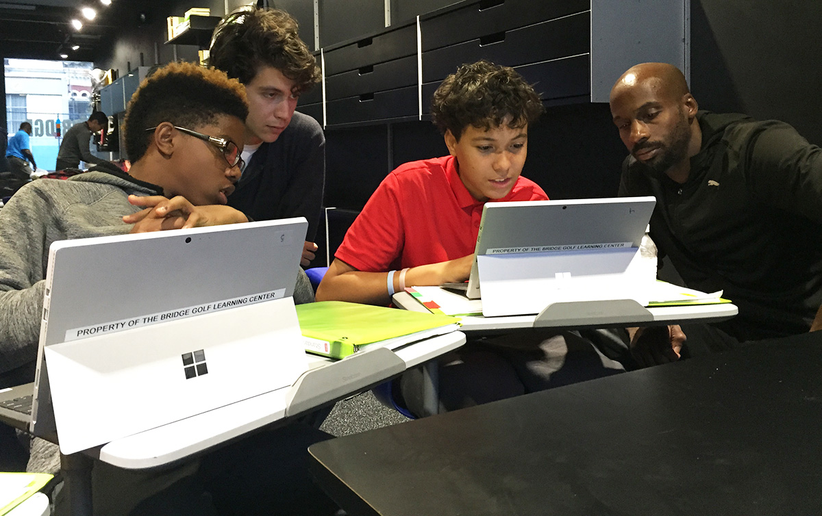 STEM teachers Rob Davis, left, and Herbert Brown worked with Jaden Jackson, left, Michael Alameda on their calculations.